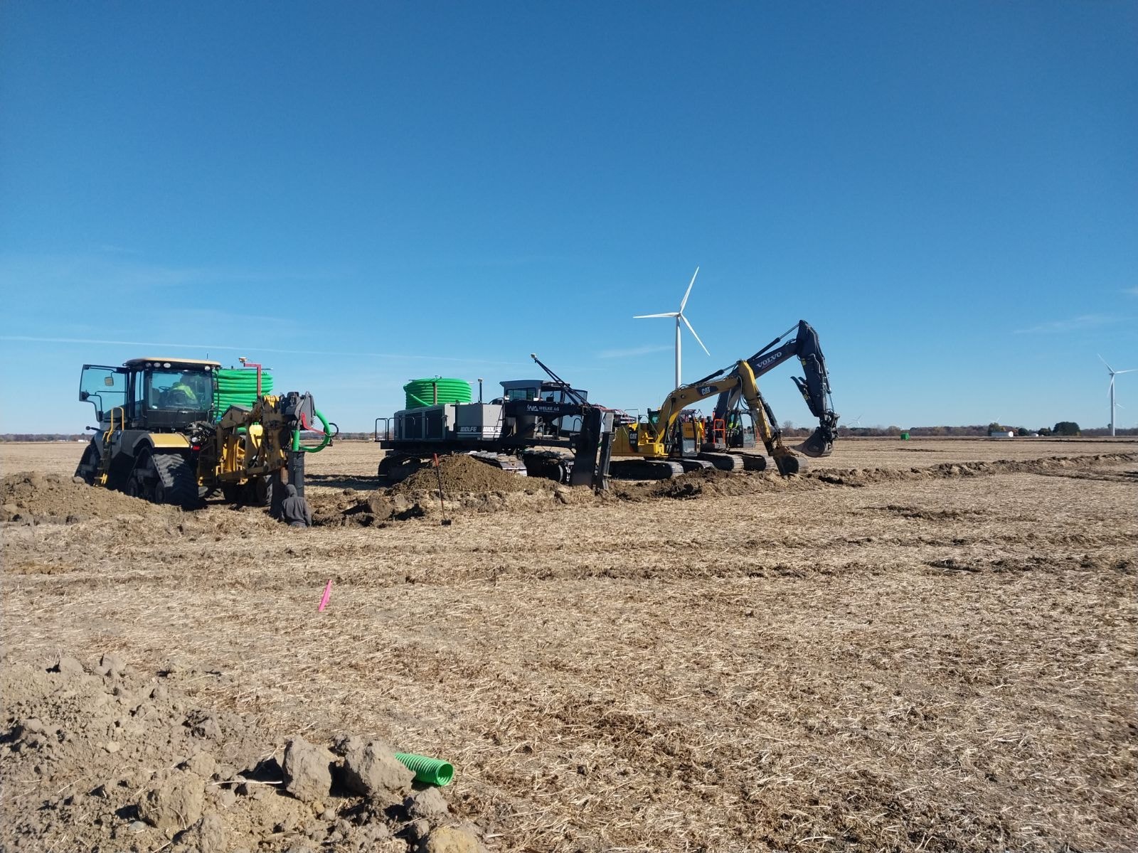 Welke Ag equipment fleet working in field with wind turbines